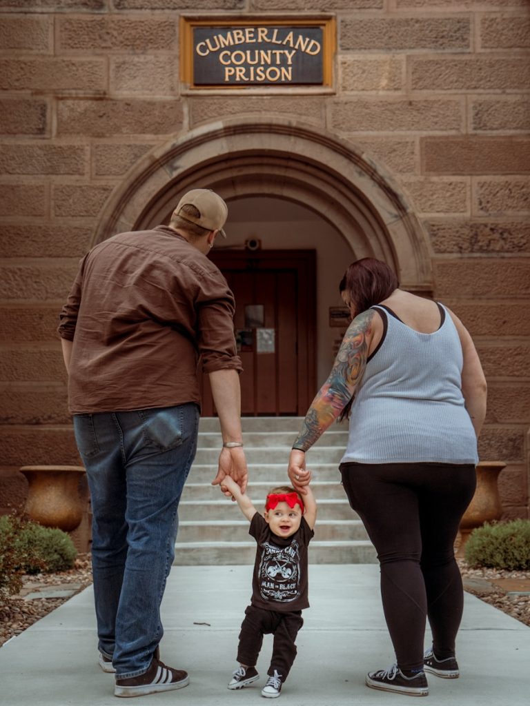 two parents holding hands of toddler walking to cumberland county prison